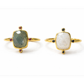 Two gold-rimmed rings with gemstones on a white background