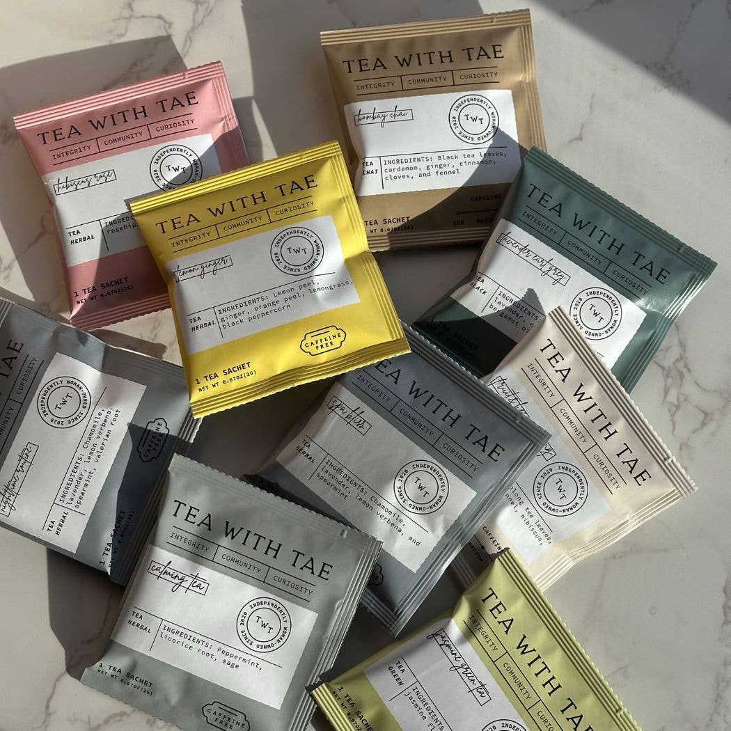 Assorted 'Tea with Tae' tea packages on a marble surface