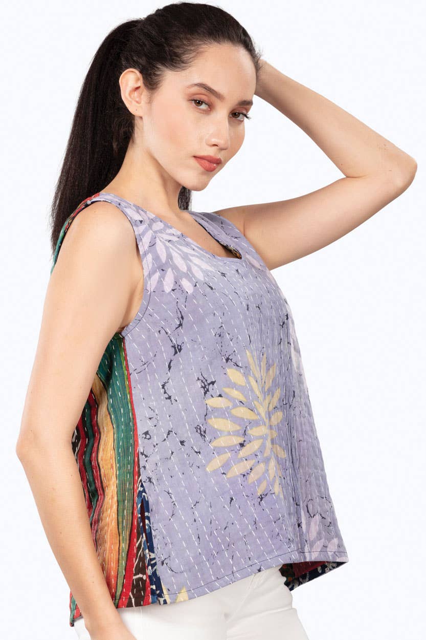 Woman wearing a sleeveless top with floral patterns on a white background