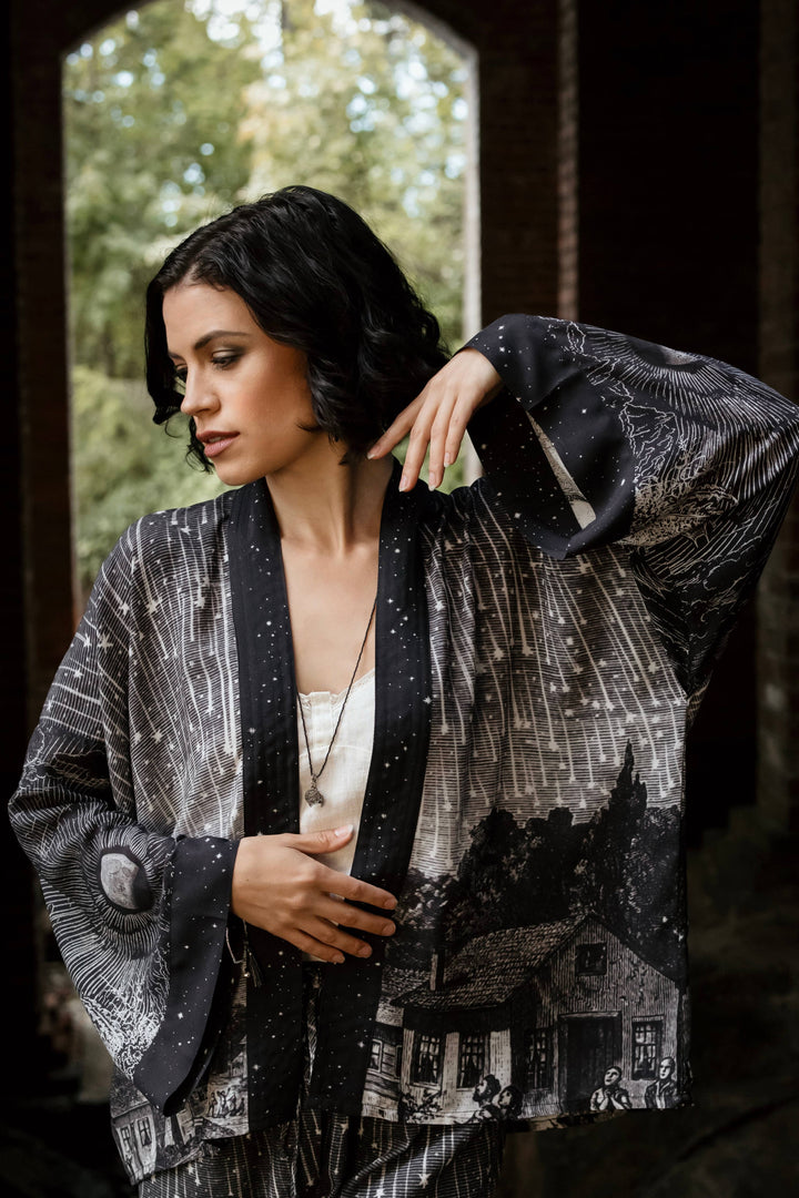 Woman wearing a black and white patterned coat with a blurred background