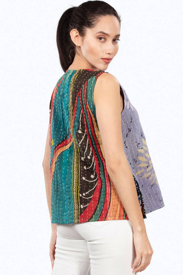 Woman wearing a colorful patterned top with a white background