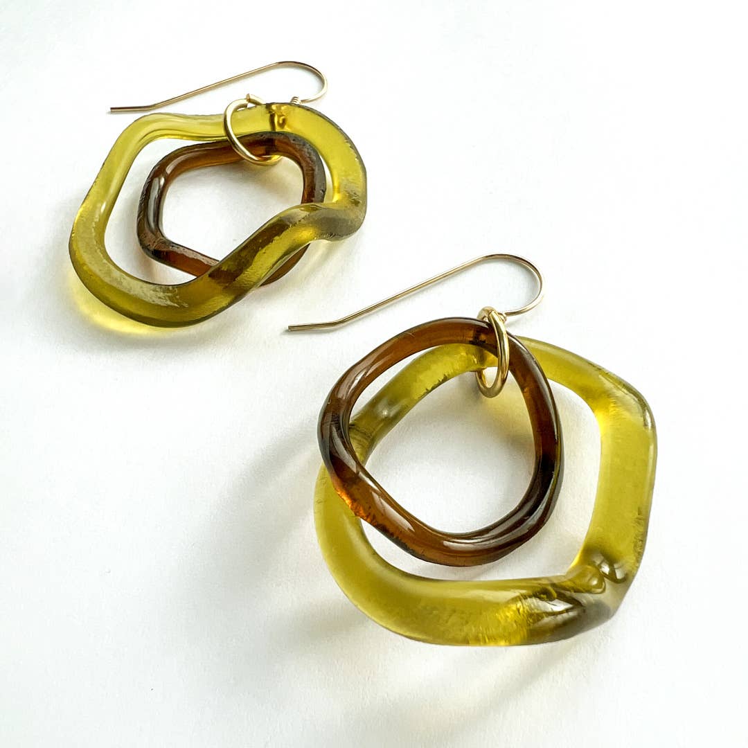 Pair of earrings with gold and brown hoop design on a white background