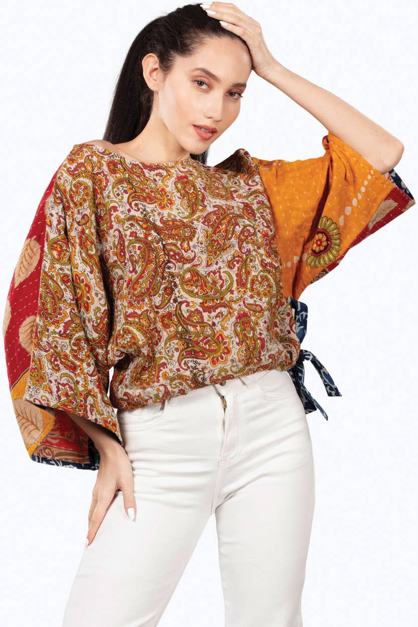 Woman wearing a patterned top with a white background