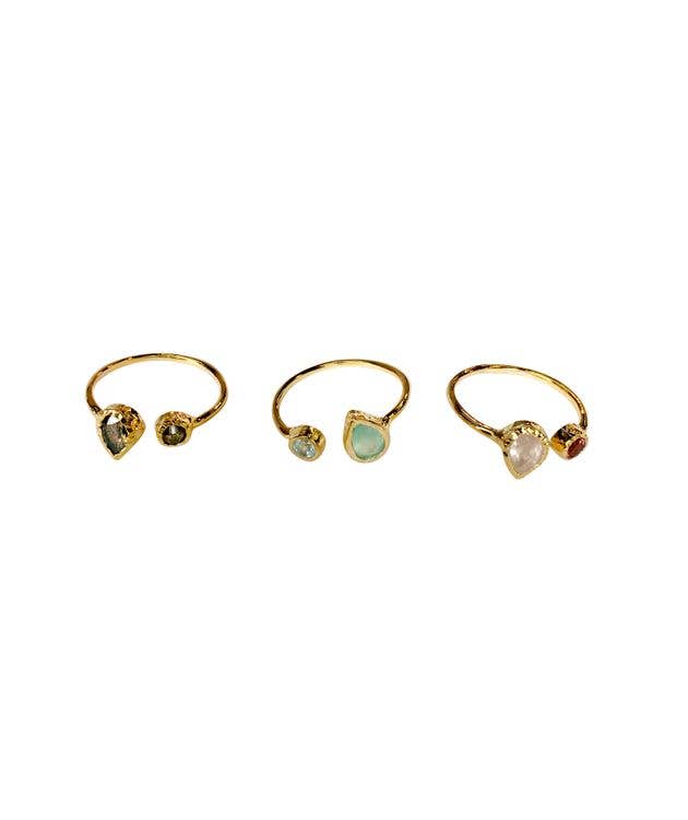 Three gold rings with gemstones on a white background