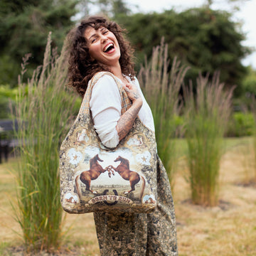 Woman holding a large patterned bag outdoors in a natural setting