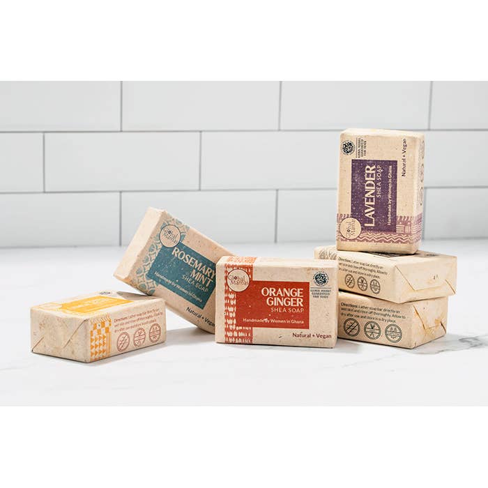 Various boxes of soap with different scents on a white surface and tiled wall background