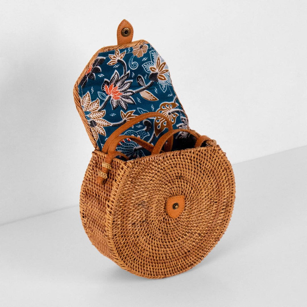 Woven bag with a floral patterned pouch inside on a white background