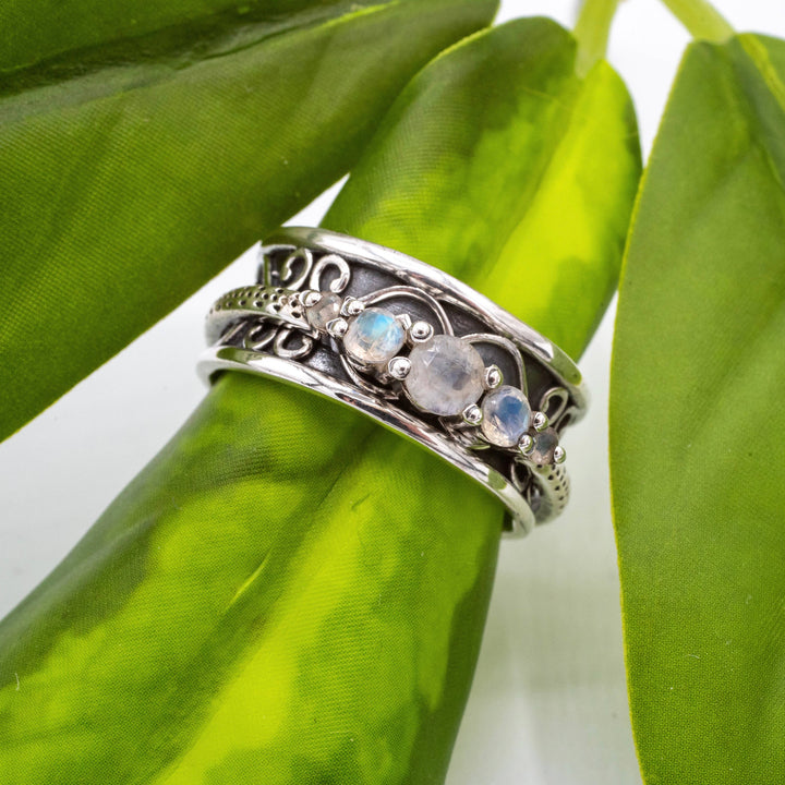 Silver ring with gemstones on a green leaf