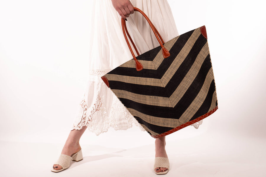 Person holding a striped bag with a white background