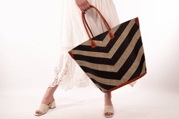 Person holding a striped bag with a white background