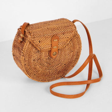 Brown woven handbag with a strap on a light gray background