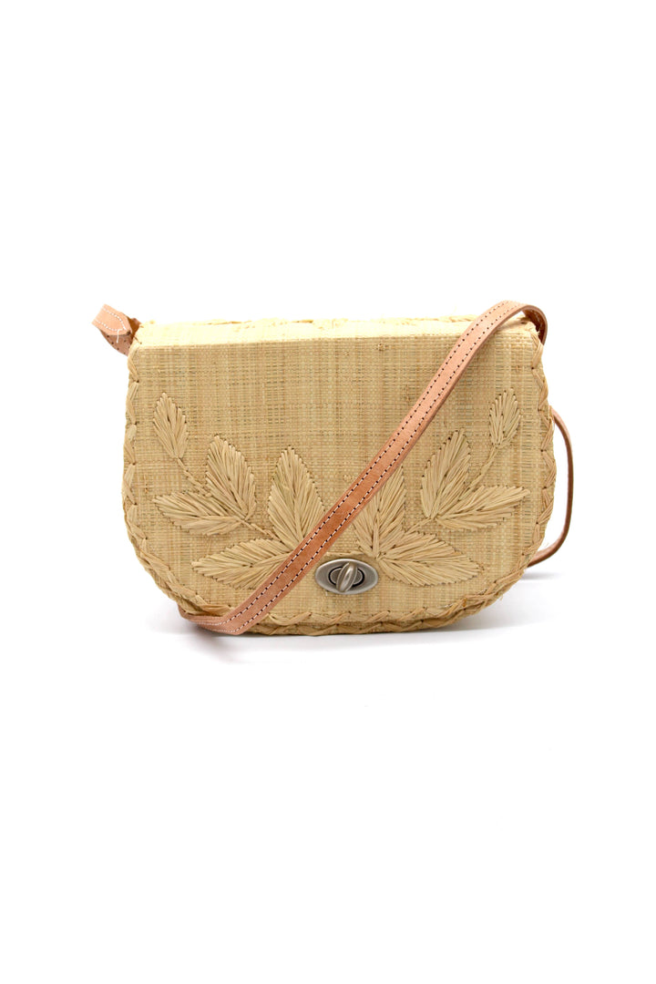 Beige woven handbag with leaf patterns on a white background