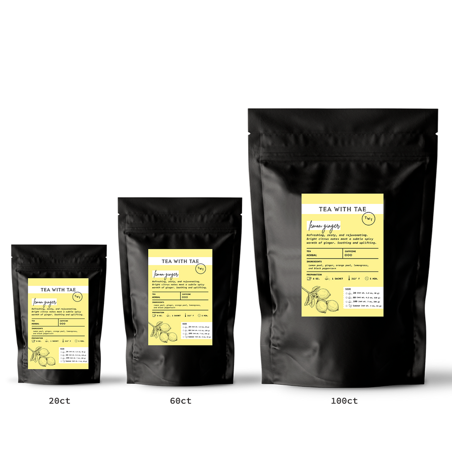 Three black tea bags with yellow labels on a white background