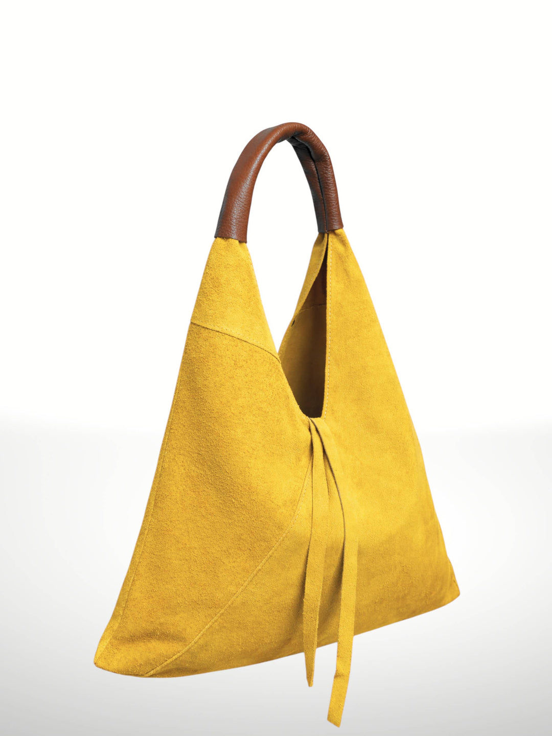 A mustard yellow suede hobo-style shoulder bag with a brown leather handle, shown on a clean white background.
