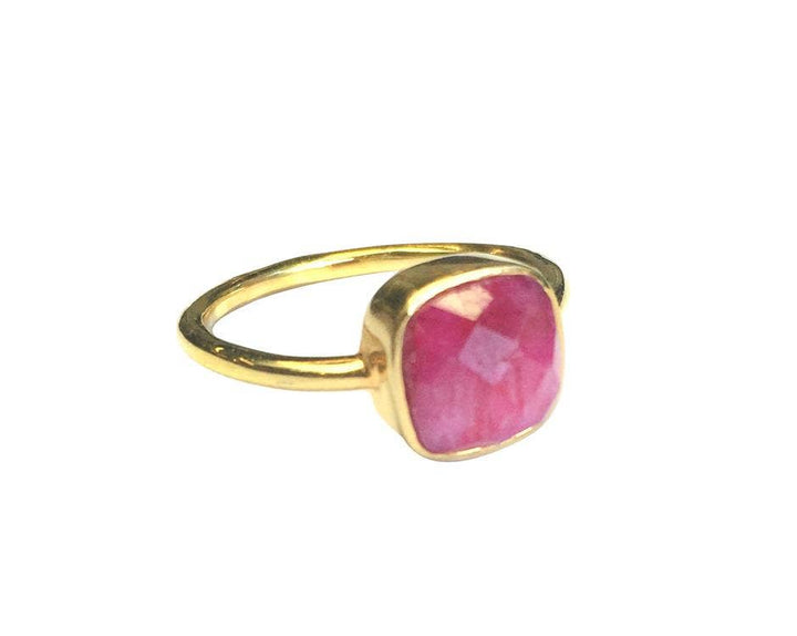 Gold ring with a pink gemstone on a white background