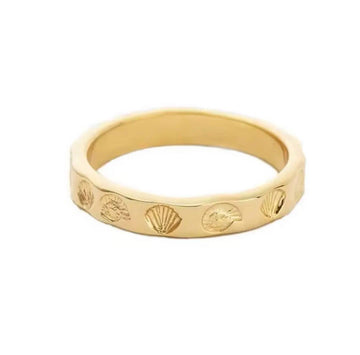 Gold ring with shell designs on a white background