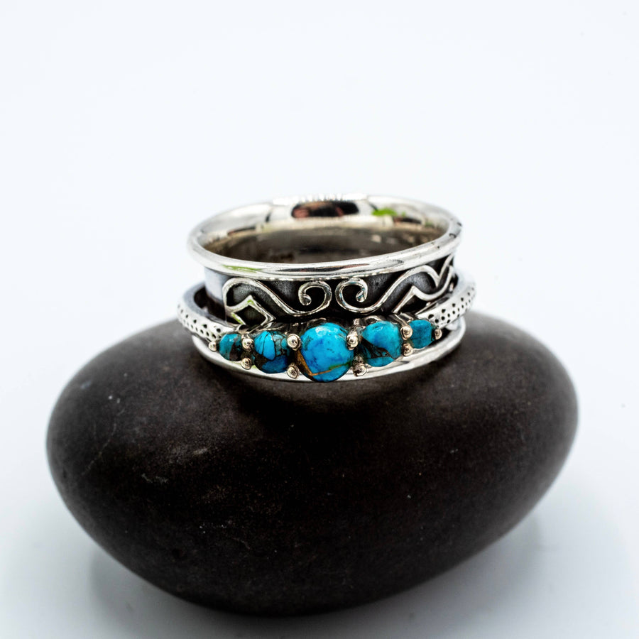 Silver ring with turquoise stones on a black stone