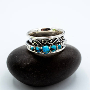 Silver ring with turquoise stones on a black stone