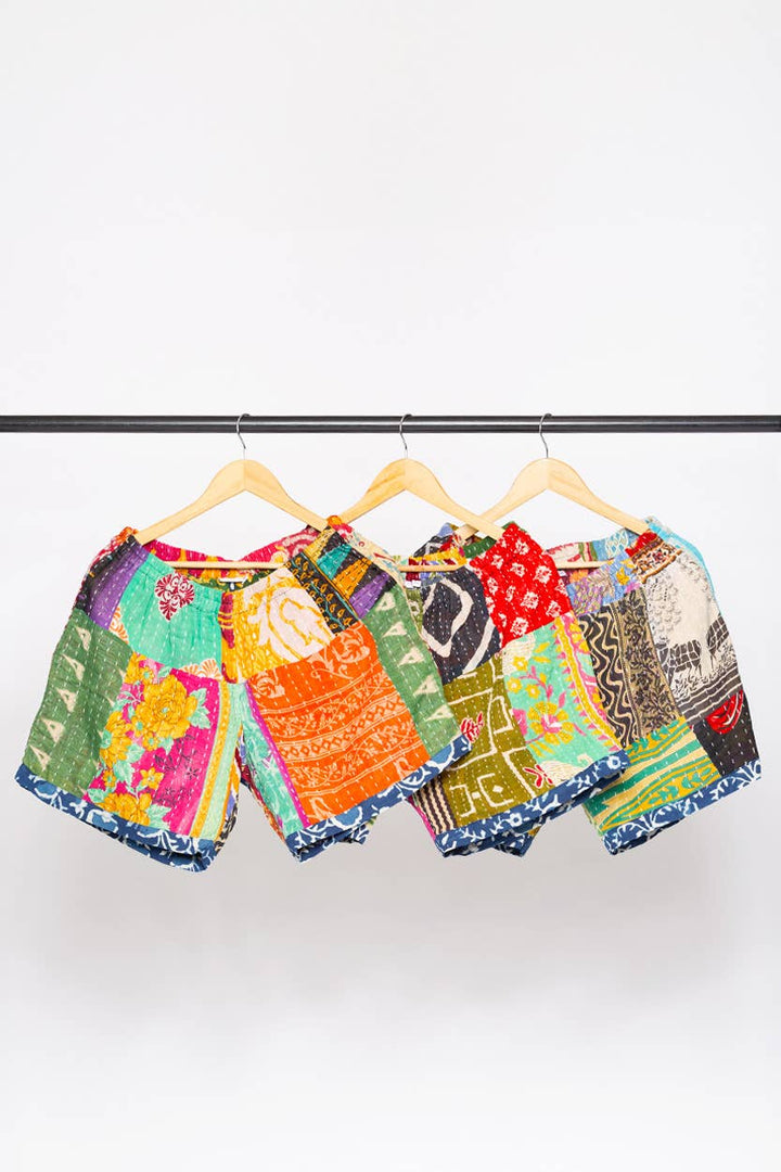 Colorful patterned shorts on hangers against a white background