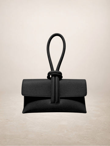A black leather clutch bag with a unique knotted top handle, displayed against a neutral beige background.