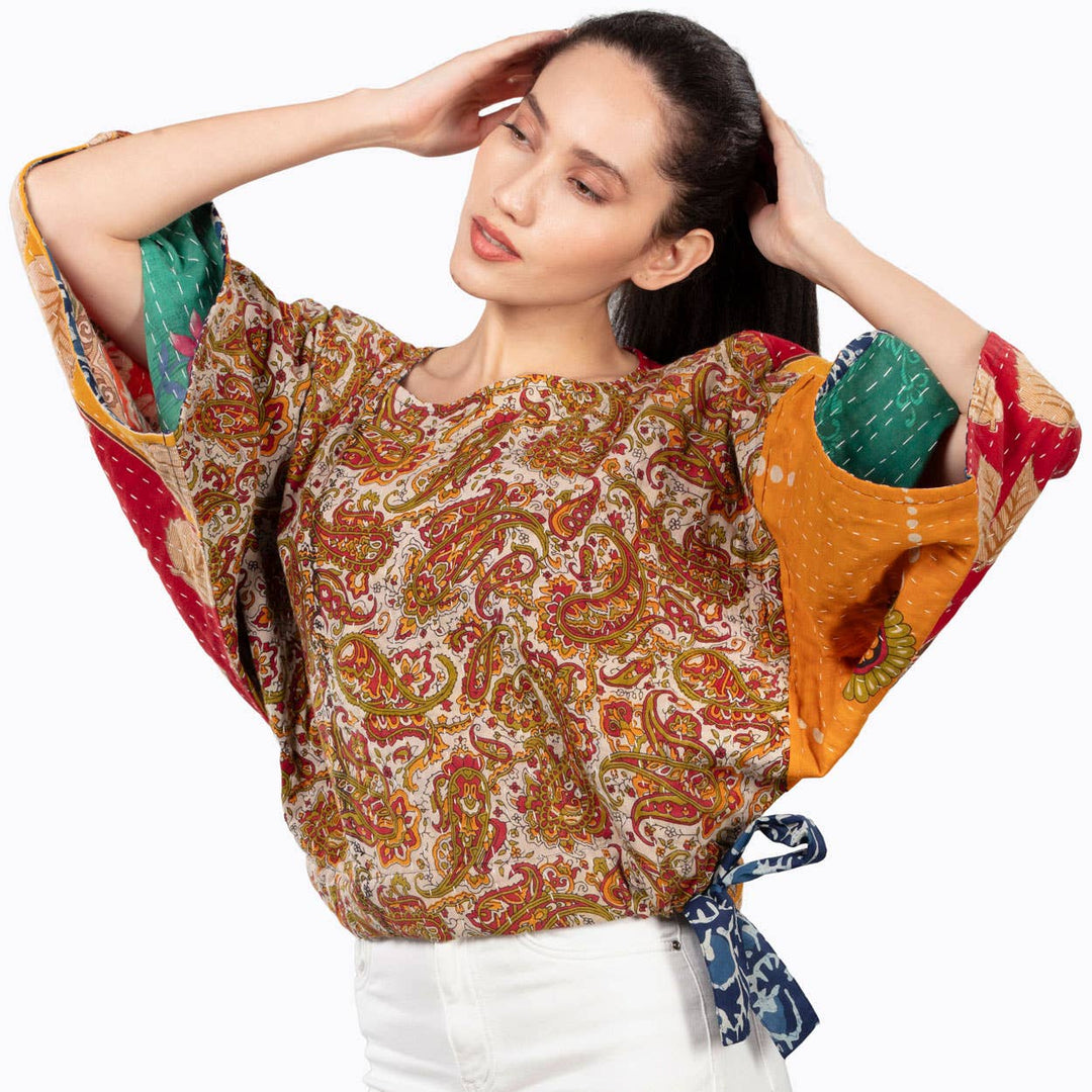 Woman wearing a colorful patterned top with a white background