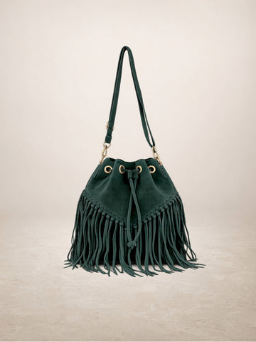 A dark green suede bucket bag with a long fringe detail, gold-tone hardware, and a matching shoulder strap, set against a neutral beige background.