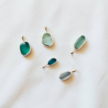 Five green teardrop-shaped pendants on a white background