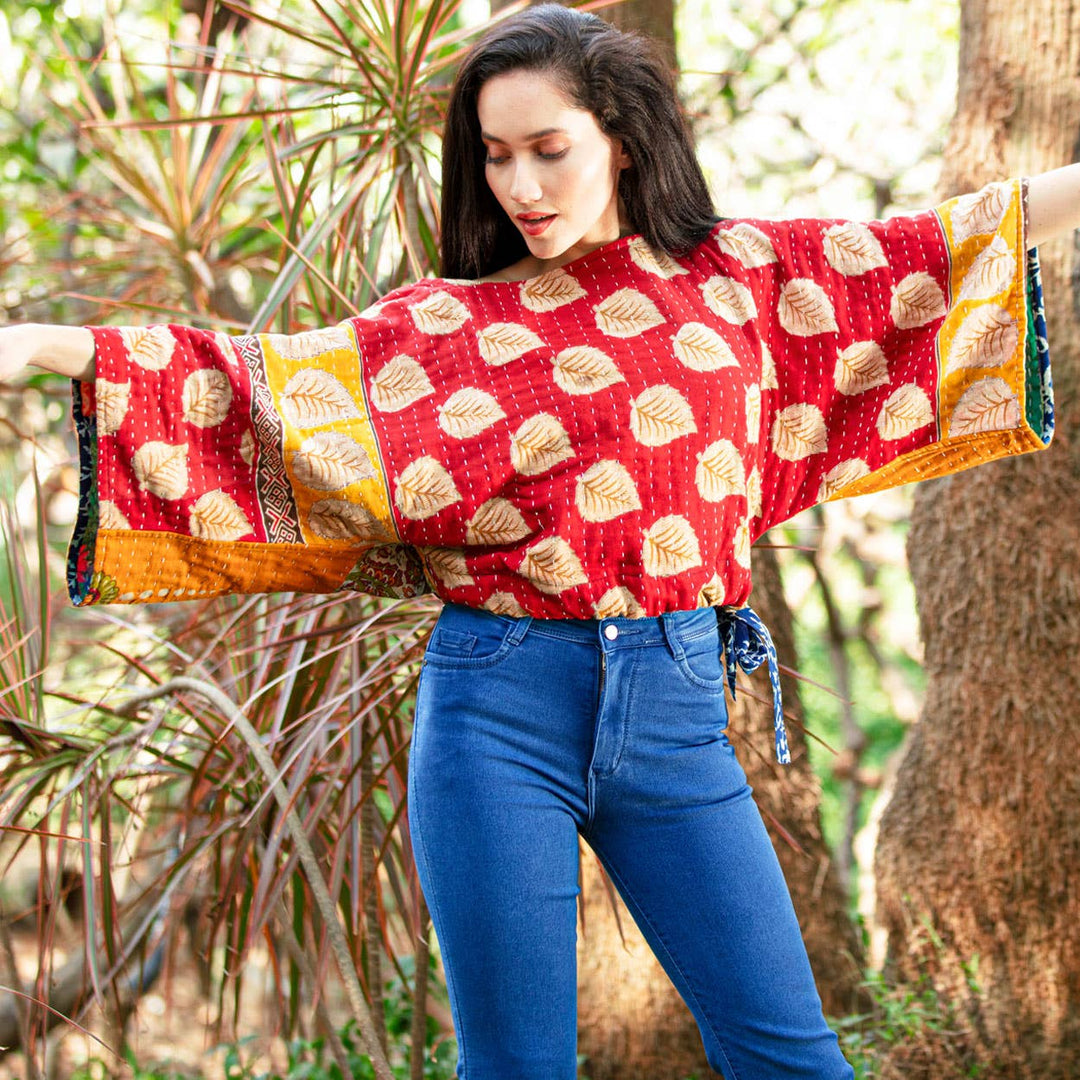 Woman wearing a colorful patterned top with long sleeves in a natural setting