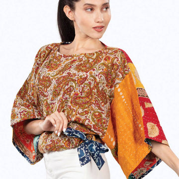 Woman wearing a colorful patterned top on a white background