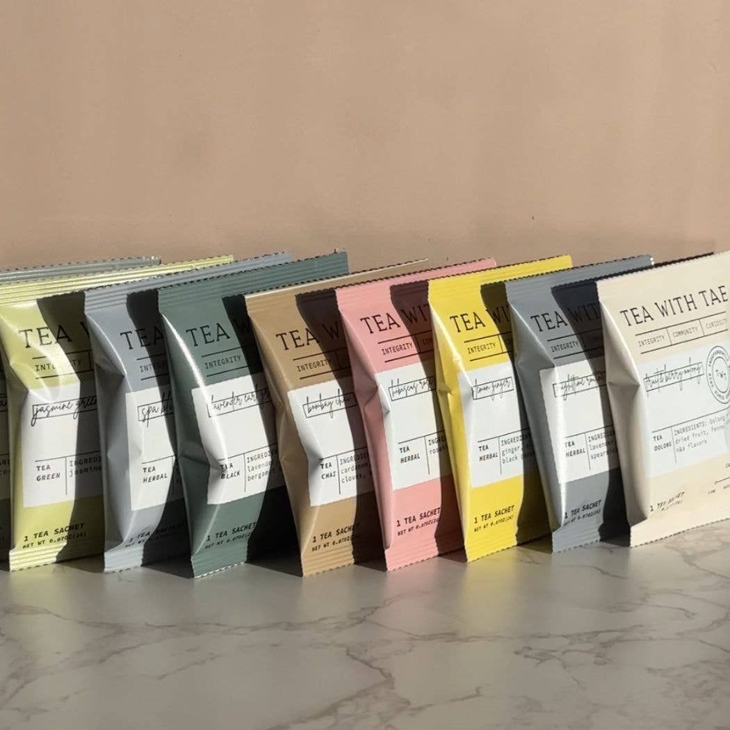 Row of tea packages with visible branding on a neutral background